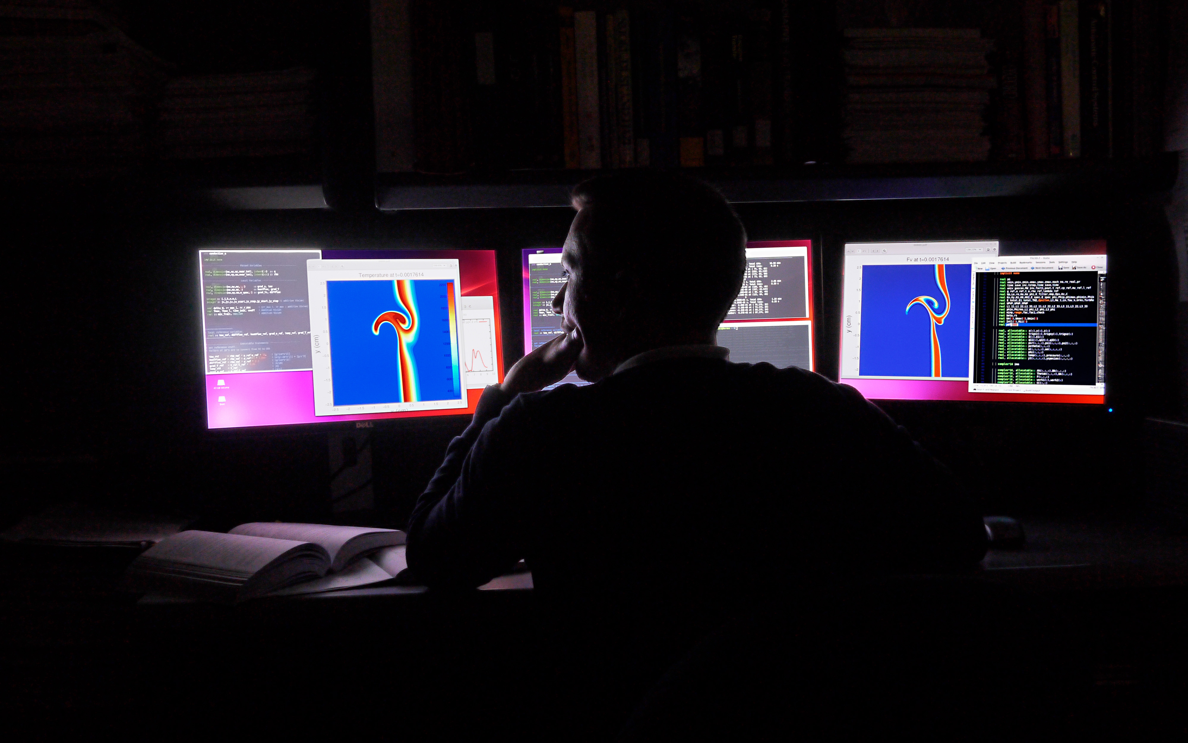 Student facing computers in dark room.