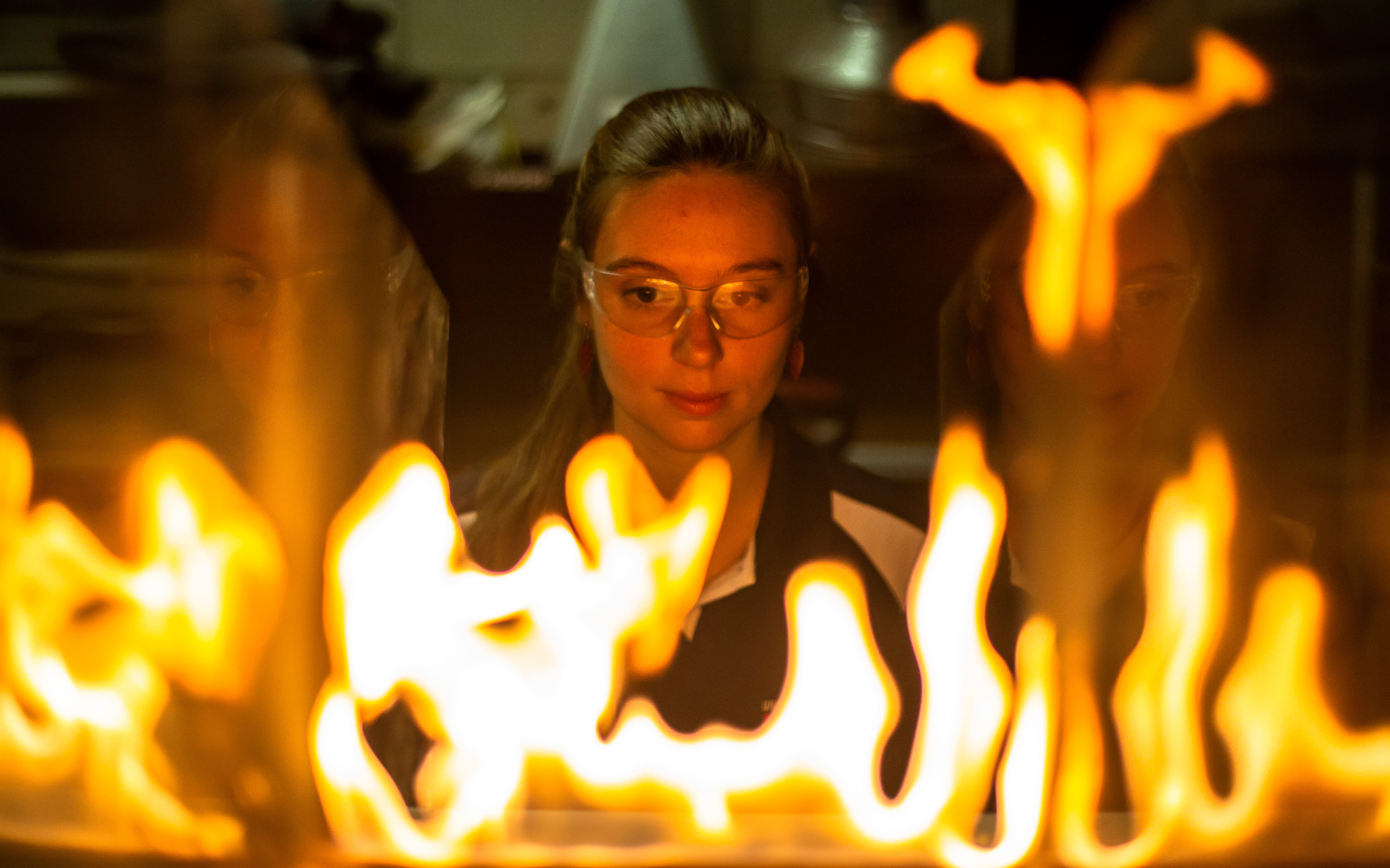 Female student observing flames.
