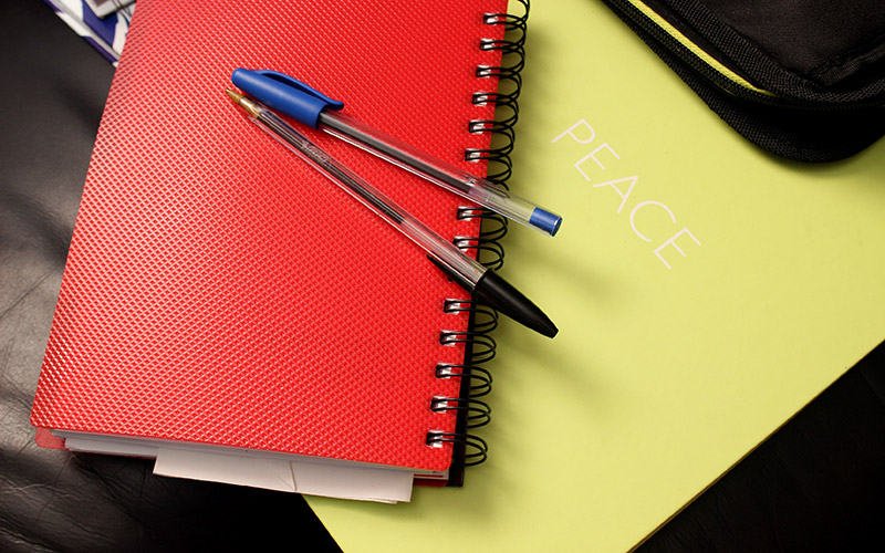 Red notebook, yellow paper, black leather bag